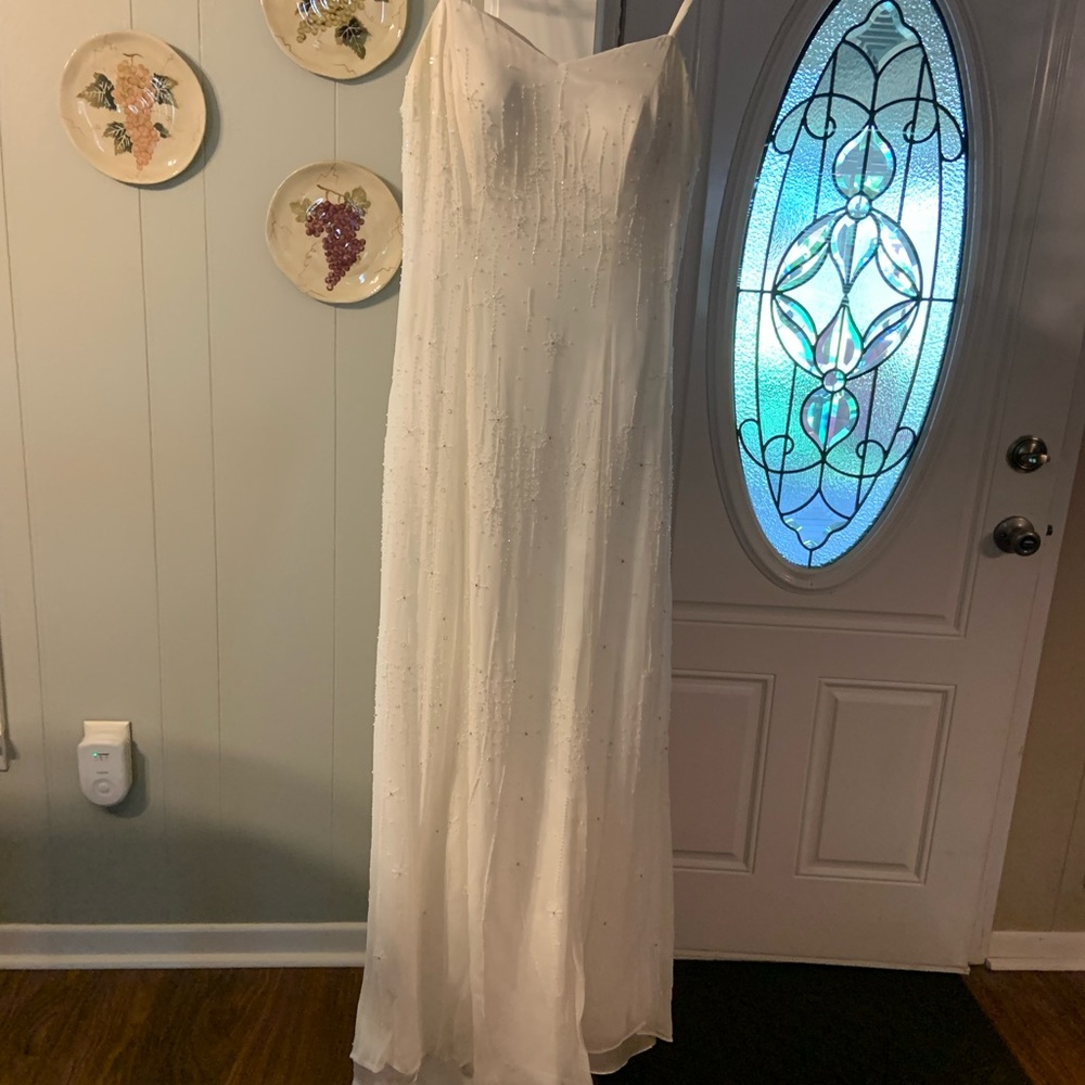 Spaghetti strapped wedding dress with small pearls all over it floor length